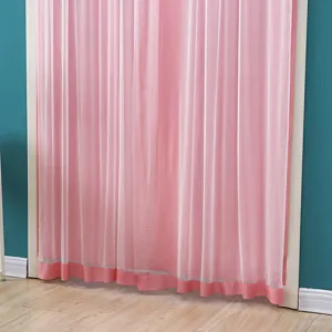 Detalle de cortina transparente rosa con textura de malla para division de puerta de dormitorio.