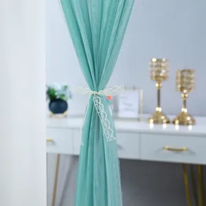 Teal tulle door curtain detail view, lightweight mesh fabric with elegant white lace tie back.