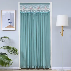 Détail de rideau de porte en dentelle verte avec broderie florale et de superbes glands.