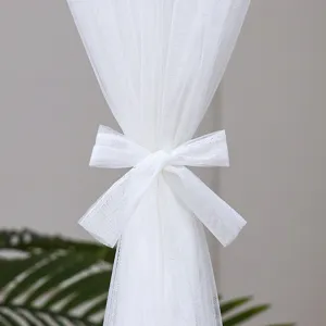 Close-up detail of white sheer lace door curtain with bow tie, elegant French style mesh.
