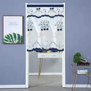 Vista detallada de la elegante cortina de encaje blanco con bordados florales y lazos azules.