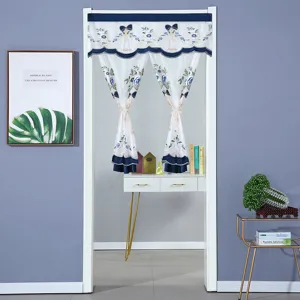 Detalle de cortina de puerta de malla de encaje bordada azul y blanca con lazo.