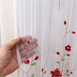 Detailed view of sheer white curtain with elegant red floral embroidery and soft mesh fabric.