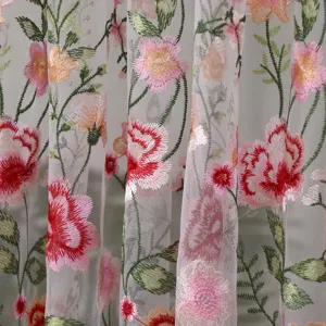 Embroidered sheer curtain fabric detail closeup showcasing delicate pink flower floral patterns.