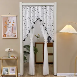 Détail de rideau de porte en dentelle française, élégant nœud noir, séparateur de pièce chic.