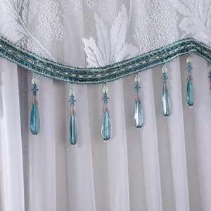 White lace dust cover detail featuring elegant blue beaded fringe trim for home appliances.