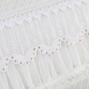 Detalle de funda cabecera de cama tul encaje blanco con elegante bordado mariposa.