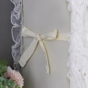 Primer plano de una funda de cabecera con delicados volantes de encaje y un bonito lazo decorativo.