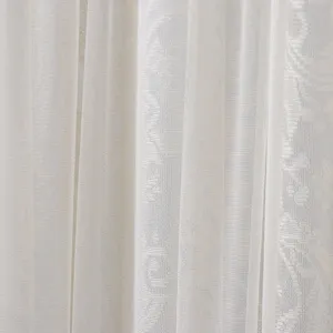 White lace curtain detail showcasing delicate sheer mesh fabric texture and elegant floral patterns.