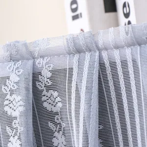 Close-up detail shot of light blue lace dust cover fabric with delicate floral and vertical stripes.