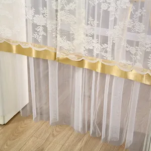 Detail view of white lace mesh door curtain with gold scalloped trim and elegant floral patterns.