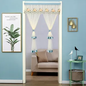 Double layer sheer door curtain with lace floral embroidery and elegant blue tiebacks for room decor.