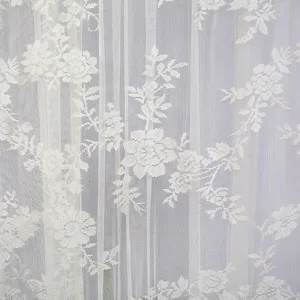 White lace curtain fabric detail showing delicate floral embroidery and vertical stripe pattern.