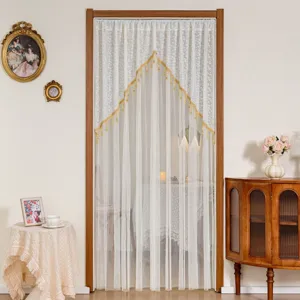 Detail shot of white lace mosquito net door curtain with gold trim, vintage bedroom decor