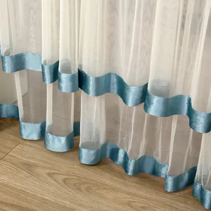 Close up of white sheer curtain with elegant blue velvet bottom trim for home bedroom window decor.