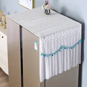White lace refrigerator dust cover detail showing delicate floral pattern and blue beaded fringe.