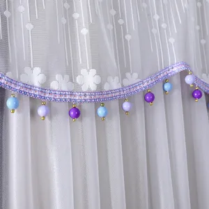 White lace refrigerator dust cover detail with purple and blue beads hanging fringe trim.