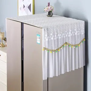 Detailed view of white lace refrigerator dust cover with gold bead fringe for home decor.