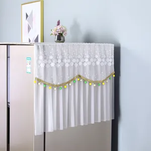 White lace refrigerator dust cover with floral embroidery and colorful beaded fringe.