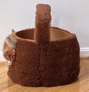 High-quality side view of shaggy brown plush Highland cow Easter basket storage