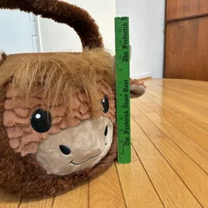 Cute plush highland cow Easter basket candy bucket shown with ruler for size measurement.