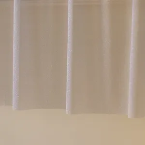 Gros plan détaillé du tissu en maille scintillant montrant une texture douce et un beau tombé.