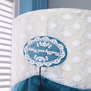 Detailed view of cylindrical air conditioner cover with white floral lace and teal velvet.