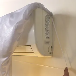 Détail de housse anti-poussière de climatiseur en dentelle avec cordon élastique et tissu.