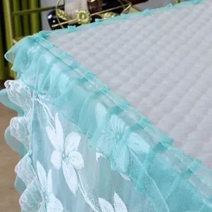 Detailaufnahme der Waschmaschinenabdeckung mit weißem Steppstoff und türkisfarbener Spitze.