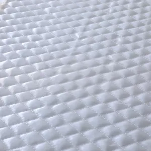 Weißer gesteppter Stoff Detail Textur Nahaufnahme, feines Rautenstepp-Muster für Abdeckung.