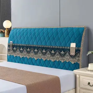 Close up of blue quilted bed headboard cover detail with decorative lace storage pockets.
