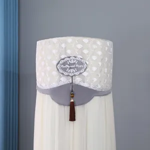 Detail view of upright cylindrical air conditioner dust cover with lace and tassels.