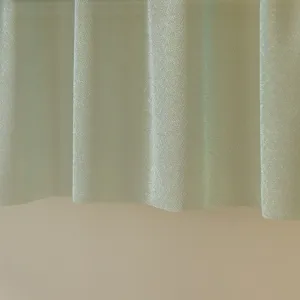 Gros plan sur la texture du tissu vert avec un fin scintillement et des plis doux.