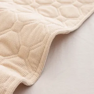 Thickened quilted headboard cover detail showing soft beige fabric and geometric pattern texture.