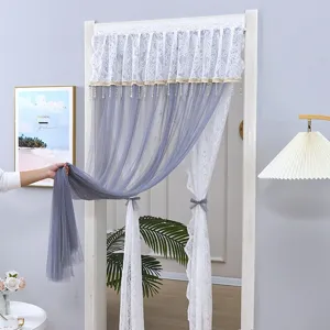 Detail view of the French lace door curtain with grey sheer gauze and elegant hanging beads.