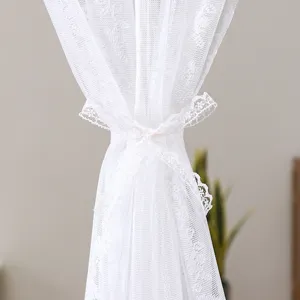 White lace half curtain detail showing elegant sheer fabric and tieback design for home decor.