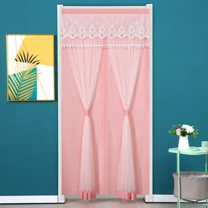 Door curtain detail showing pink sheer lace and delicate embroidery in bedroom scene