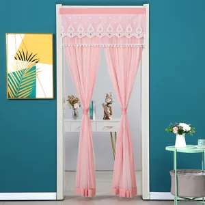 Pink sheer door curtain with lace trim and pom-pom fringe, ideal for room partition decor.