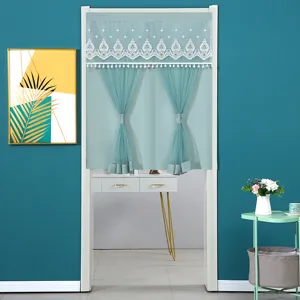 Door curtain detail showing delicate white lace embroidery and turquoise sheer fabric.