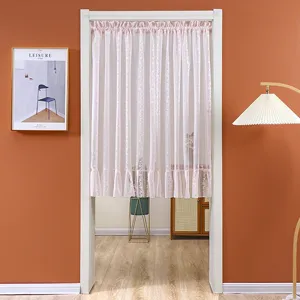 Pink lace door curtain detail in a cozy room, showing delicate pleated gauze fabric.