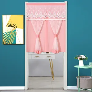 Detail view of the pink door curtain featuring delicate white lace and pompom trim in room setup.