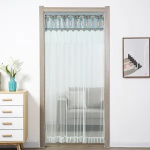 Dettaglio della tenda da porta in rete a doppio strato con mantovana blu e nappe eleganti.