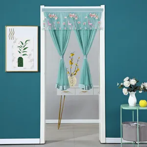 Detail shot of mint green lace door curtain with floral deer embroidery in home scene.