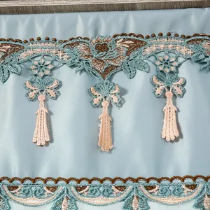 Vista dettagliata di squisita tenda ricamata in pizzo con nappe, elegante appendiabiti da porta blu.
