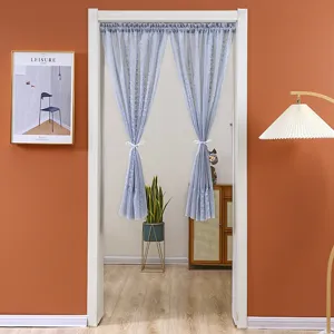 Detailed view of light blue lace door curtain hanging in a cozy home doorway scene.