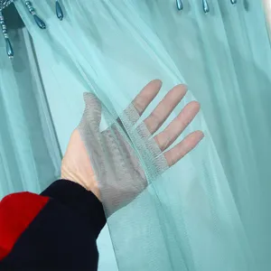 Detail view of turquoise mesh curtain fabric, breathable sheer double-layer door curtain material.