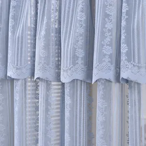Blue lace curtain detail view, elegant floral pattern tier sheer fabric for home decor.