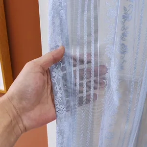 Close-up detail of light blue lace sheer door curtain, showing delicate floral pattern texture.