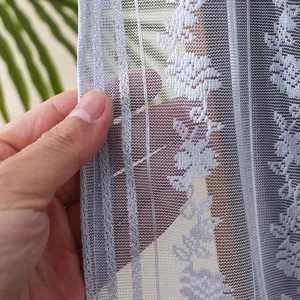 Close up view of blue lace dust curtain mesh texture and floral embroidery detail for home.