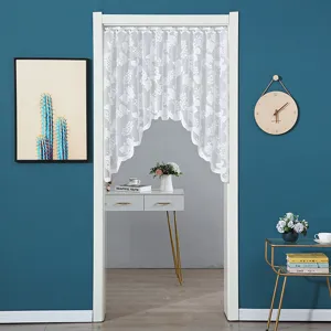 Detail view of white lace door curtain, delicate floral pattern, elegant home decor.